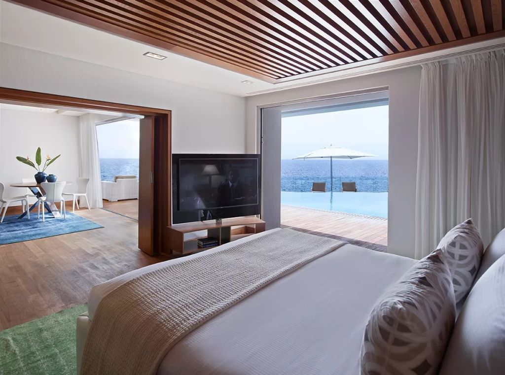 Schlafzimmer mit direktem Zugang zu privatem Pool und Meerblick