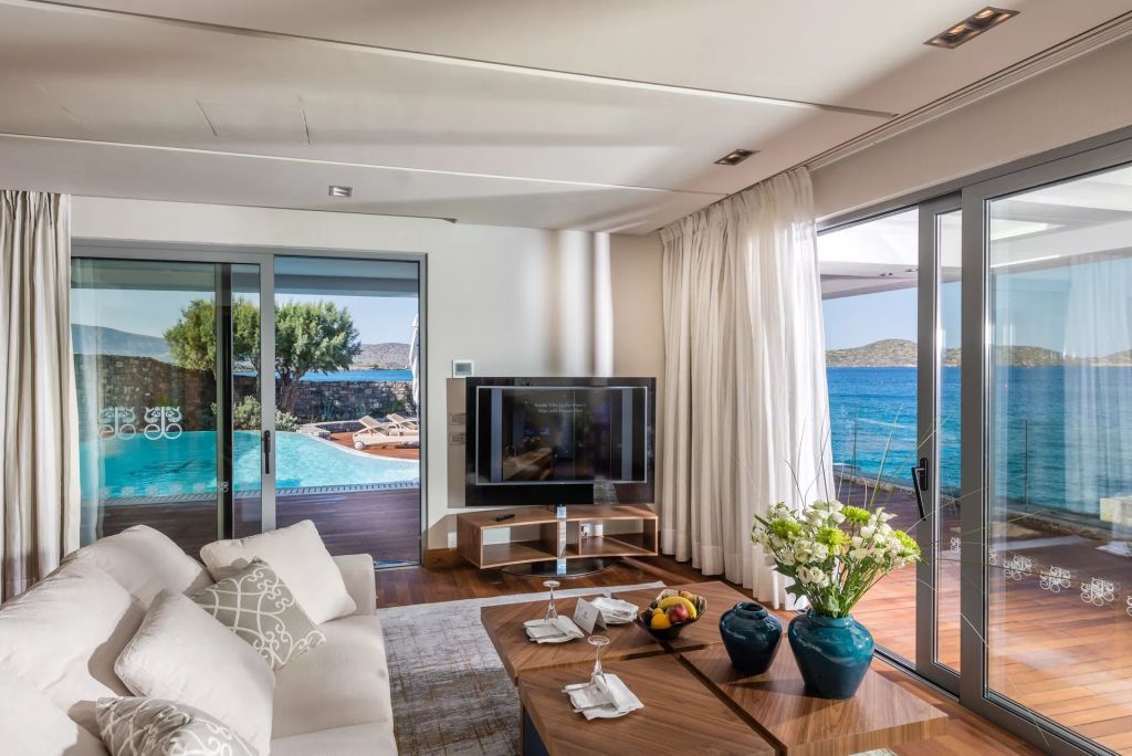 Wohnzimmer mit Zugang zur Terrasse und privatem Pool, umgeben von Natur