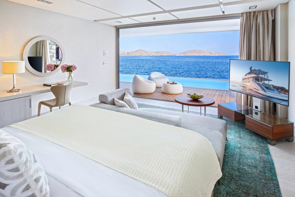 Helles Schlafzimmer mit direktem Zugang zum Pool und Meerblick
