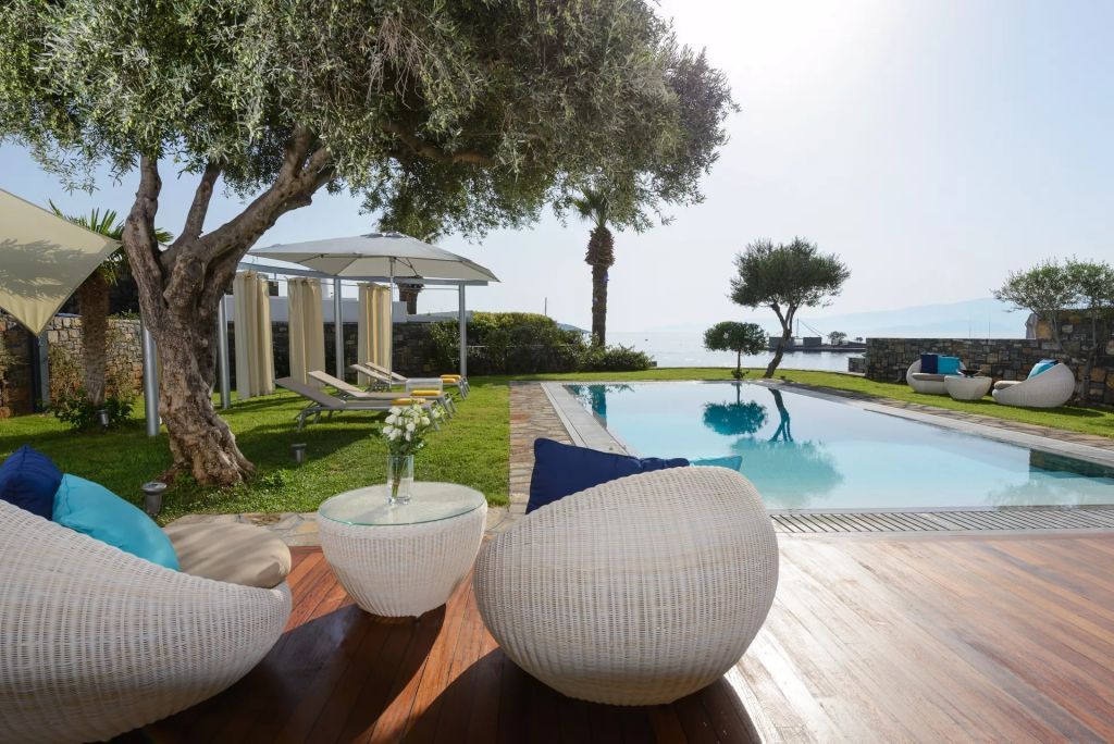 Entspannte Terrasse mit Pool, Liegestühlen und Meerblick