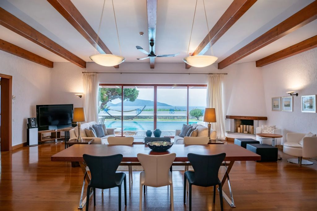 Eleganter Raum mit Esstisch und Panoramafenstern mit Meerblick