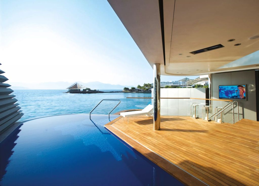 Privater Holzterrasse mit Infinity-Pool und spektakulärer Aussicht auf das Meer bei Sonnenschein