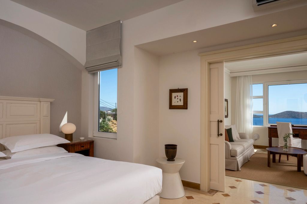 Helles Schlafzimmer mit Blick auf den Wohnbereich durch geöffnete Doppeltür