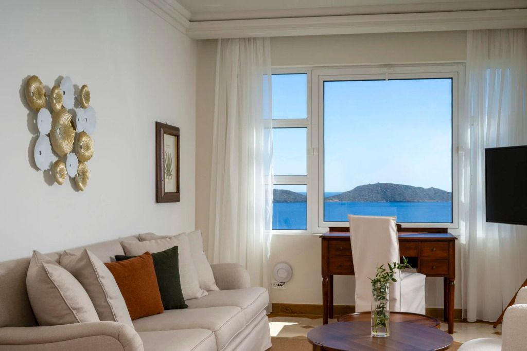 Gemütlicher Wohnbereich mit Sofa, Schreibtisch und Meeresblick