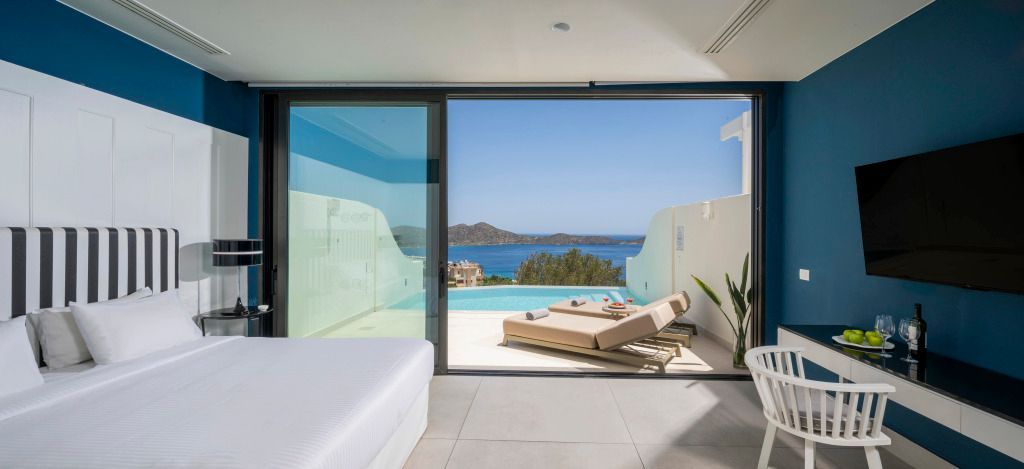 Luxuriöser Innenbereich einer Suite mit offener Aussicht auf den blauen Ozean und Pool