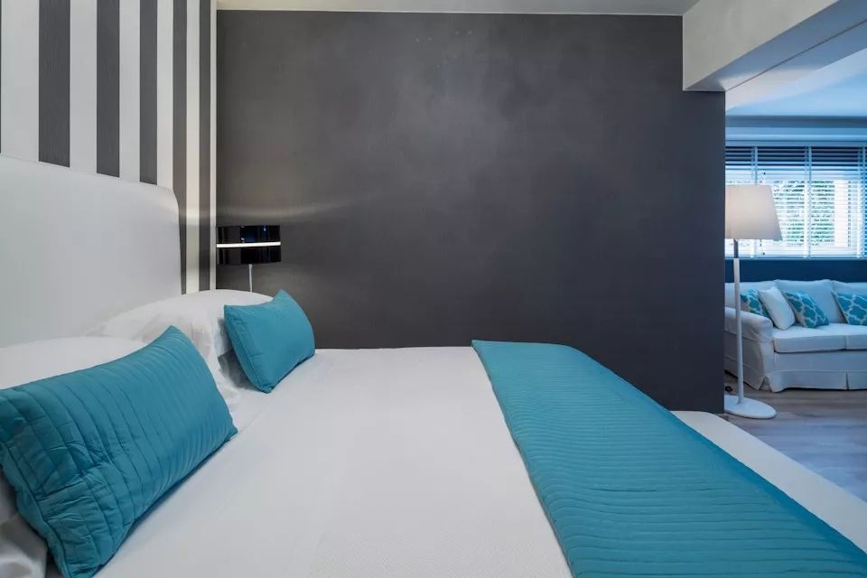 Doppelbett mit blauen Akzenten in einem modern gestalteten Schlafzimmer.