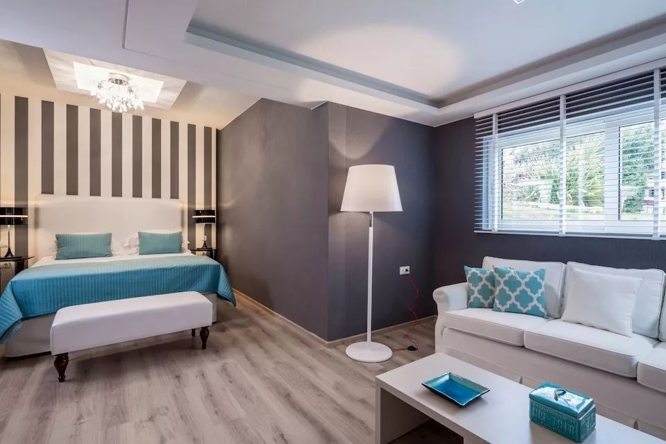 Wohnbereich mit Sofa und Schlafzimmer mit neutralen Farben und luxuriösem Design.