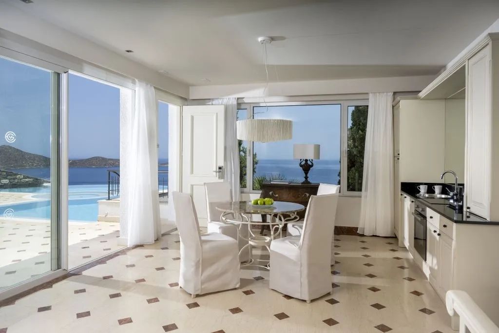 Essbereich mit Blick auf den Pool und das Meer durch große Fenster