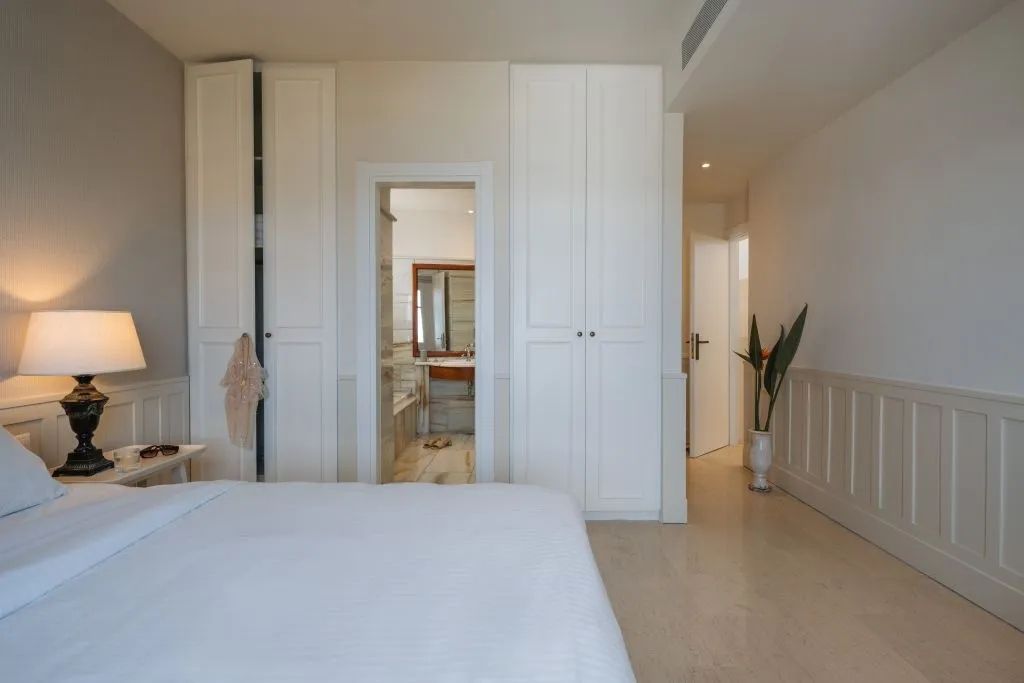 Gemütliches Schlafzimmer mit Zugang zum Badezimmer und großer Kleiderschrankwand