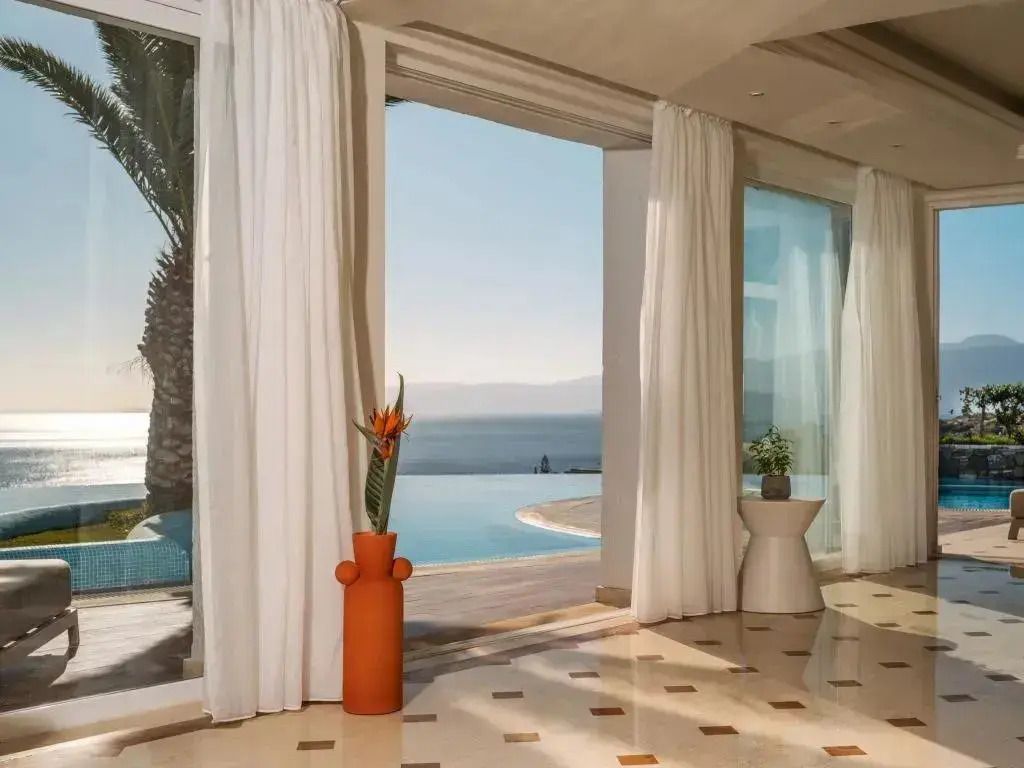 Raum mit großen Fenstern und Meerblick neben privatem Pool