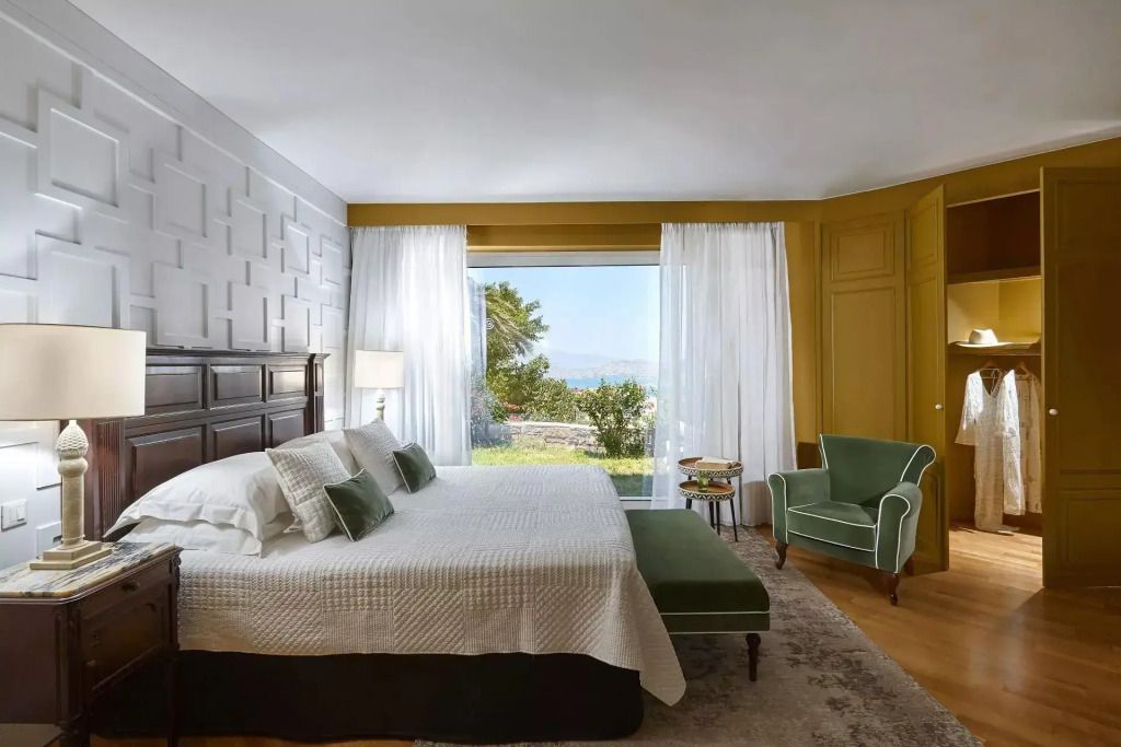 Gemütliches Schlafzimmer mit großem Fenster und Gartenblick
