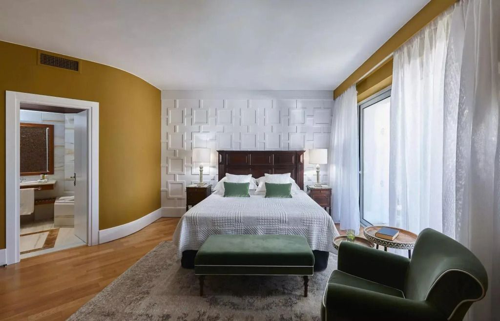 Geräumiges Schlafzimmer mit weißer und goldener Wandgestaltung