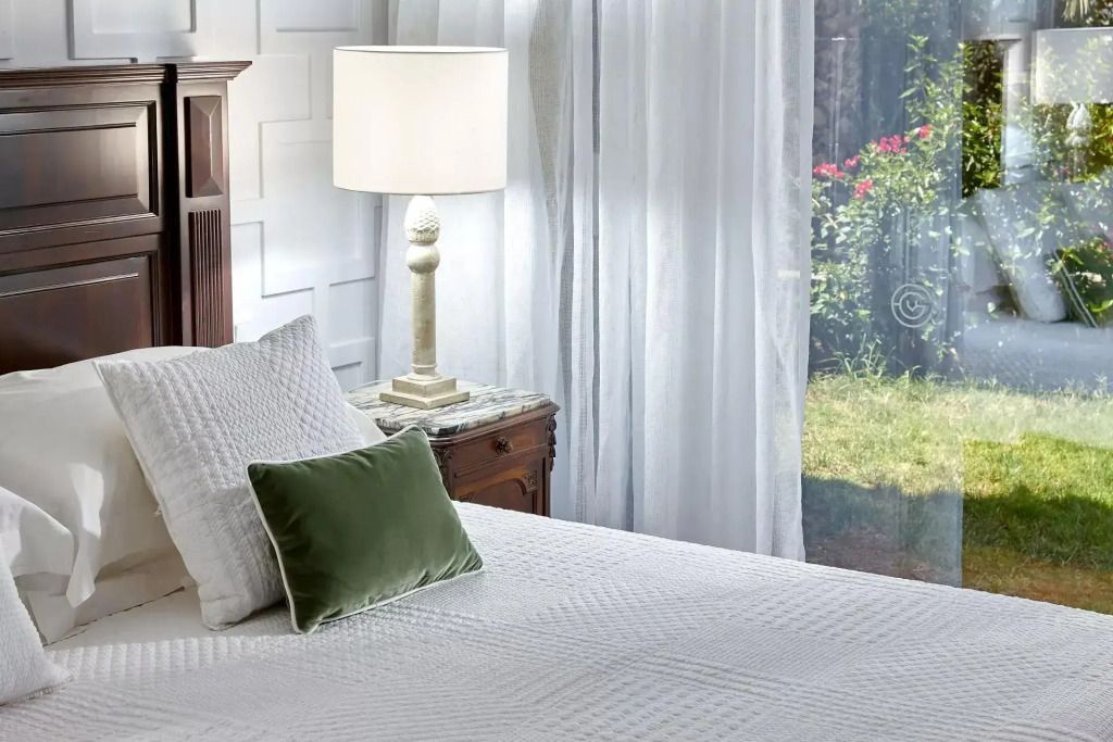 Doppelbett in einem hellen Raum mit modernen Akzenten und Gartenblick