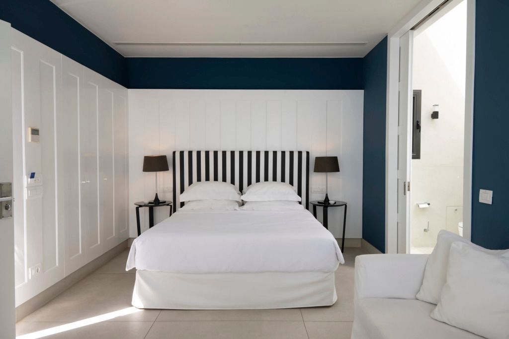 Elegantes Schlafzimmer mit Doppelbett und kontrastreichem Streifendesign