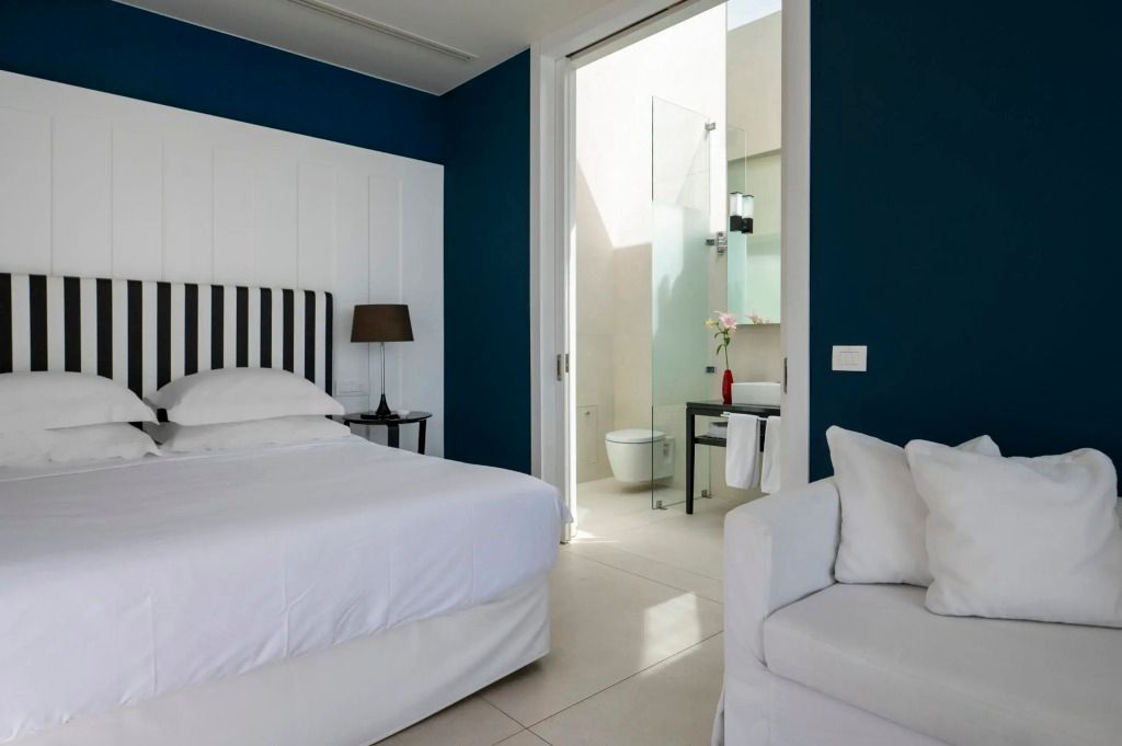 Schlafzimmer mit Zugang zu einem hellen, modernen Badezimmer