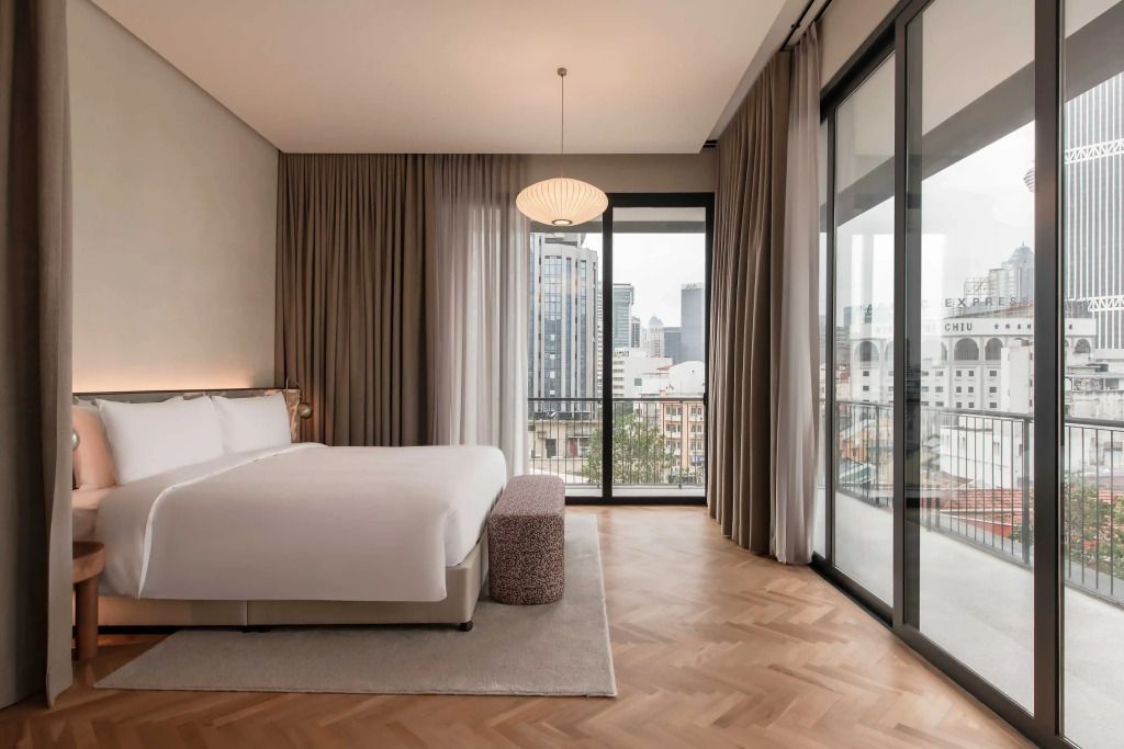 Suite-Schlafzimmer mit großem Fenster und Aussicht auf die Stadt