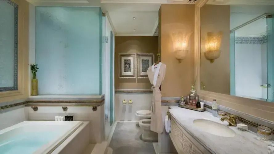 Badezimmer einer Suite mit eleganten Oberflächen und dekorativen Elementen.
