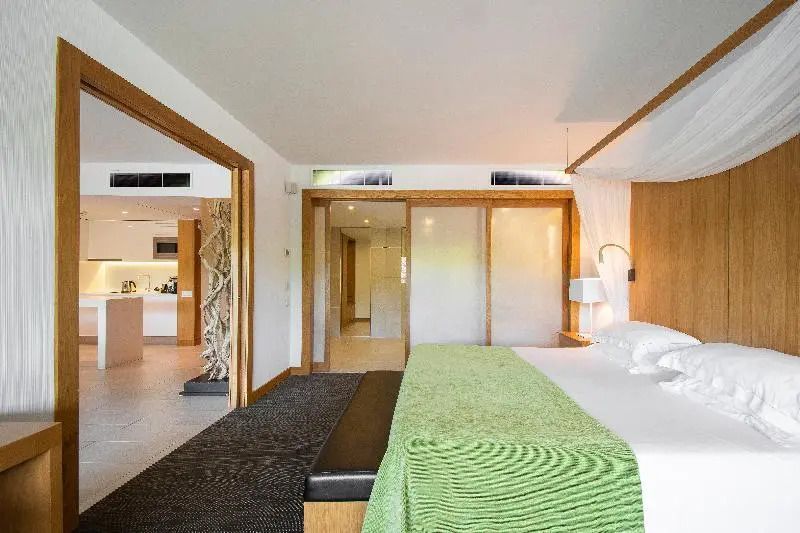 Geräumiges Schlafzimmer im Apartment mit Balkon und modernen Holzakzenten