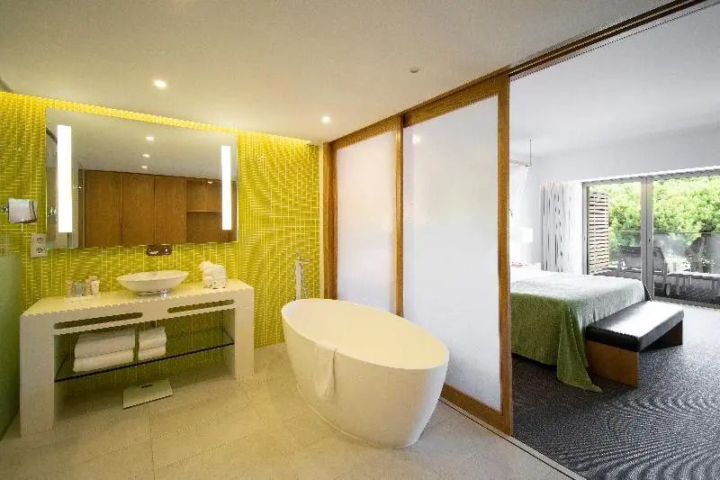 Luxuriöses Badezimmer mit freistehender Badewanne und grünen Fliesen