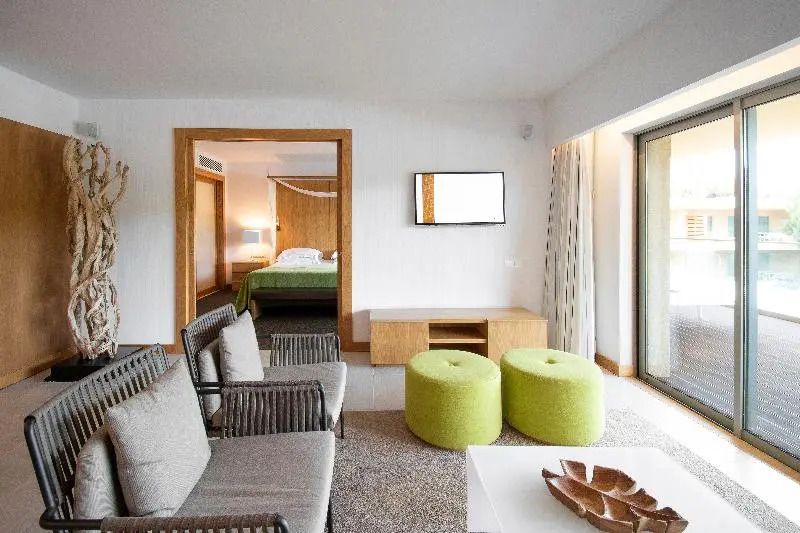 Gemütliches Wohnzimmer im Apartment mit großen Fenstern und Sitzgelegenheiten