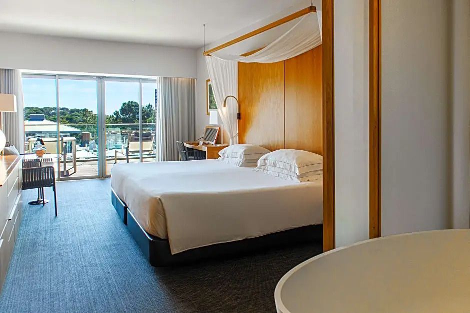 Geräumiges Schlafzimmer mit Doppelbett, hölzerner Akzentwand und Balkonzugang
