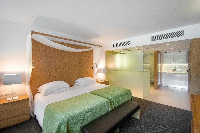 Doppelbett im Doppel Studio mit grünen Akzenten und modernem Badezimmer