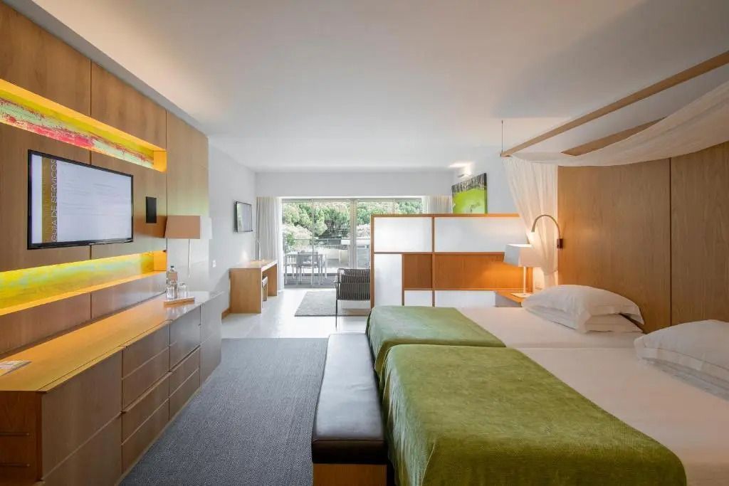Helle Junior-Suite mit Gartenblick, moderne Einrichtung und Balkon.
