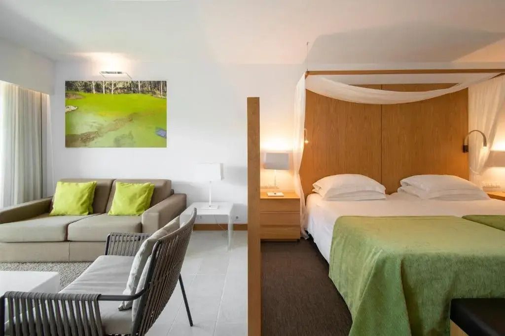 Junior-Suite mit Teilung zwischen Schlaf- und Wohnbereich, moderne Einrichtung.