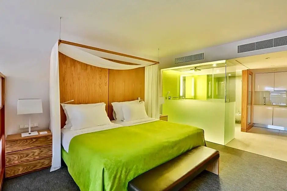 Schlafzimmer mit großem Bett und offenem Badezimmer im Standard Apartment.