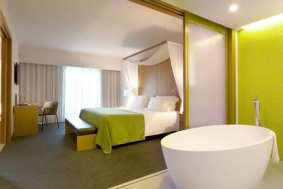 Geräumiges Schlafzimmer mit separater Badewanne im offenen Bereich.