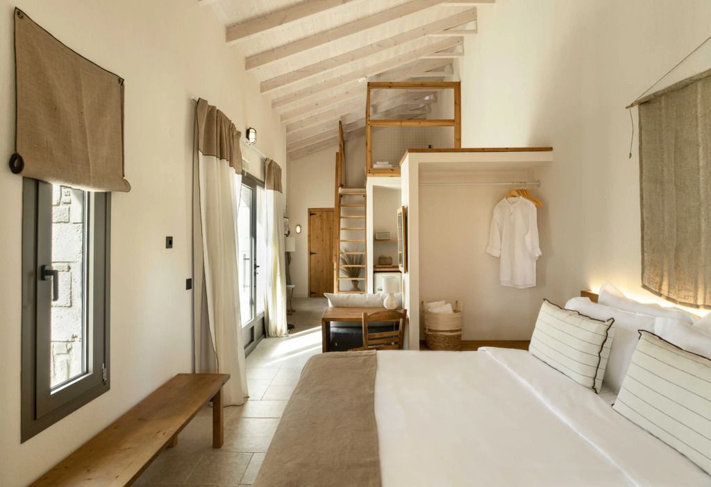 Helles Schlafzimmer mit offenem Dachbalken und gemütlichem Bett