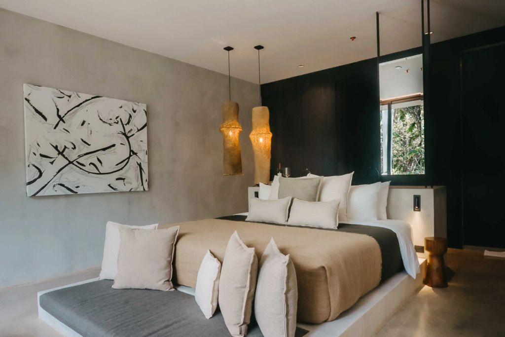 Elegantes Schlafzimmer mit modernen Leuchten und abstrakter Kunst