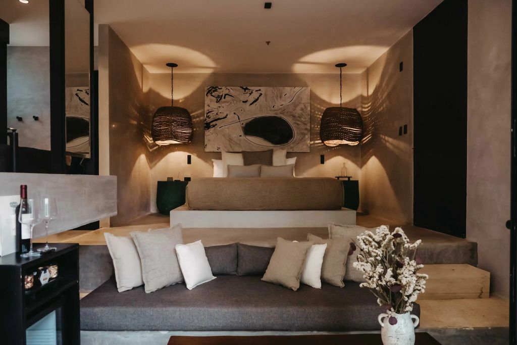 Gemütliche Sitzecke mit Blick auf ein großes Doppelbett und warm beleuchtetes Ambiente.
