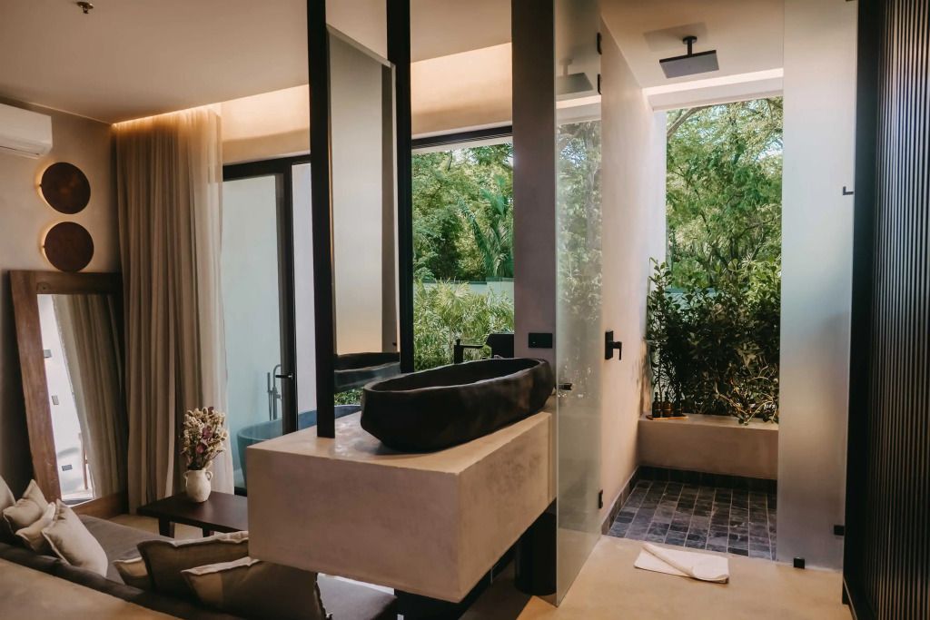 Offener Badezimmerbereich mit luxuriöser Ausstattung und herrlichem Gartenblick.