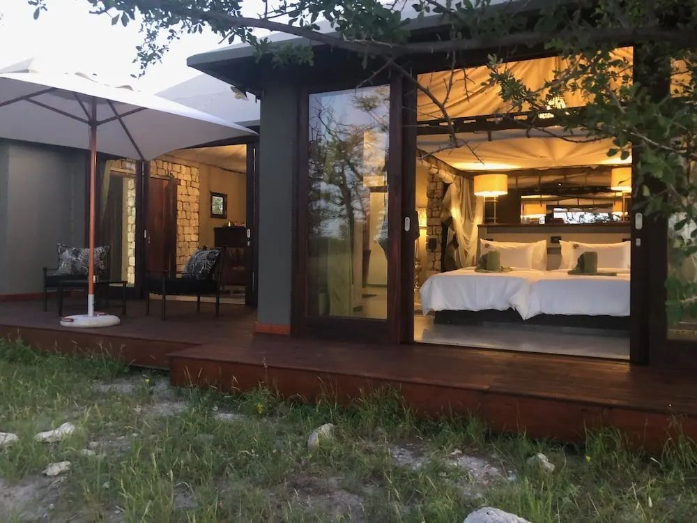 Exterieur eines Premium Chalets mit offenen Türen zur Terrasse und Doppelbett im Inneren