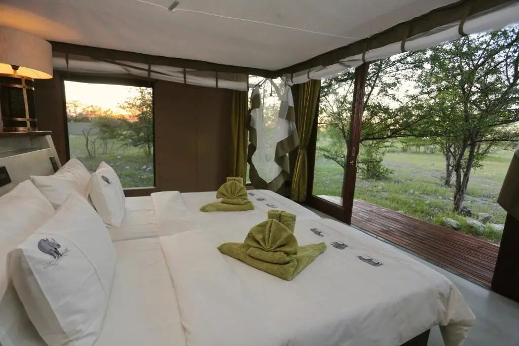 Helles Schlafzimmer mit Panoramafenstern und weißer Bettwäsche