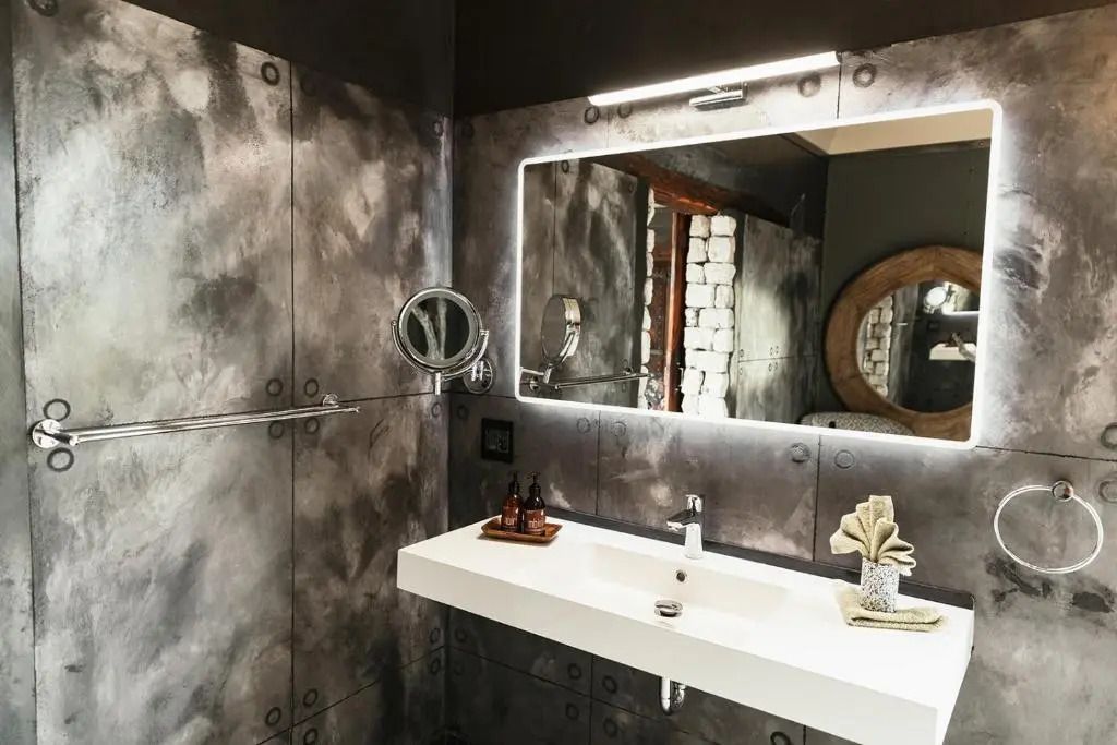 Modernes Badezimmer mit beleuchtetem Spiegel und schmuckvollem Waschbecken