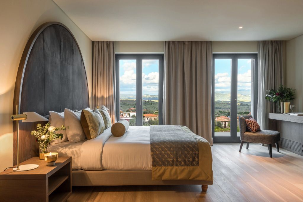 Geräumige Suite mit großem Bett und Balkon mit beeindruckendem Ausblick.
