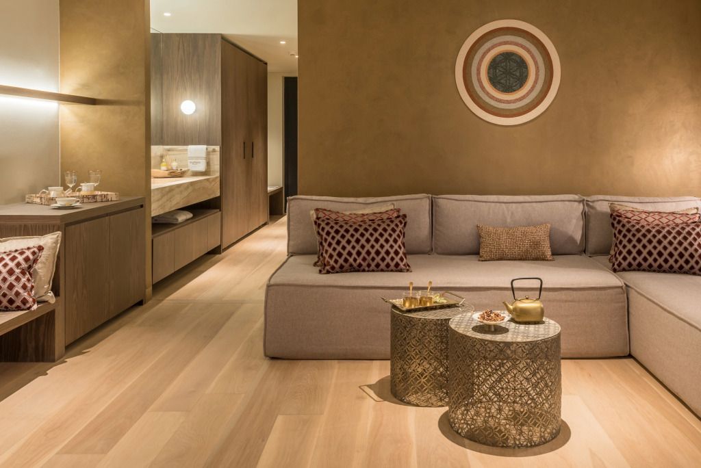 Wohnbereich der Suite mit modernem Sofa und kunstvollen Akzenten.