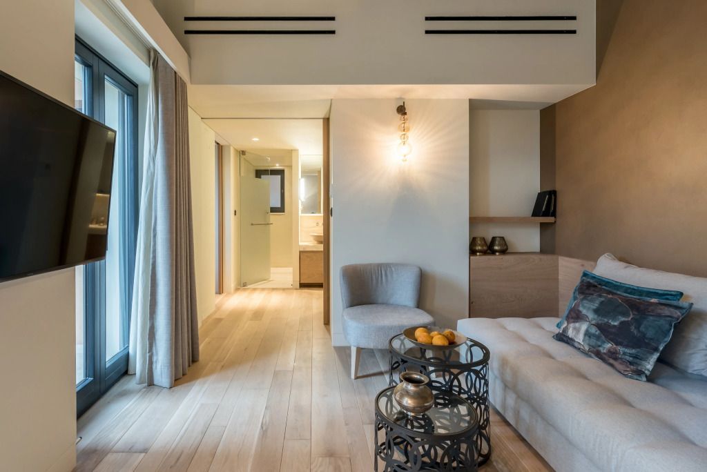 Helles Wohnzimmer der Executive Suite mit modernem Design und Blick ins Badezimmer.