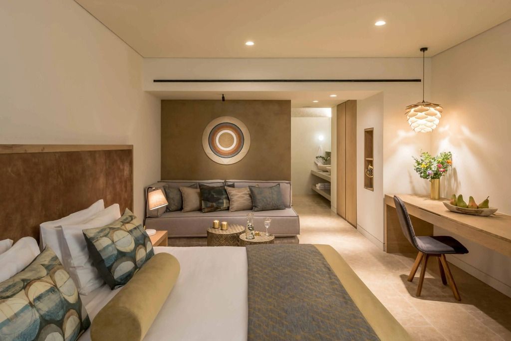 Geräumiges Hotelzimmer mit Doppelbett und gemütlicher Sitzecke