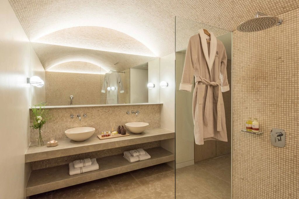 Badezimmer mit hochwertigen Materialien und flauschiger Bademantel an der Tür