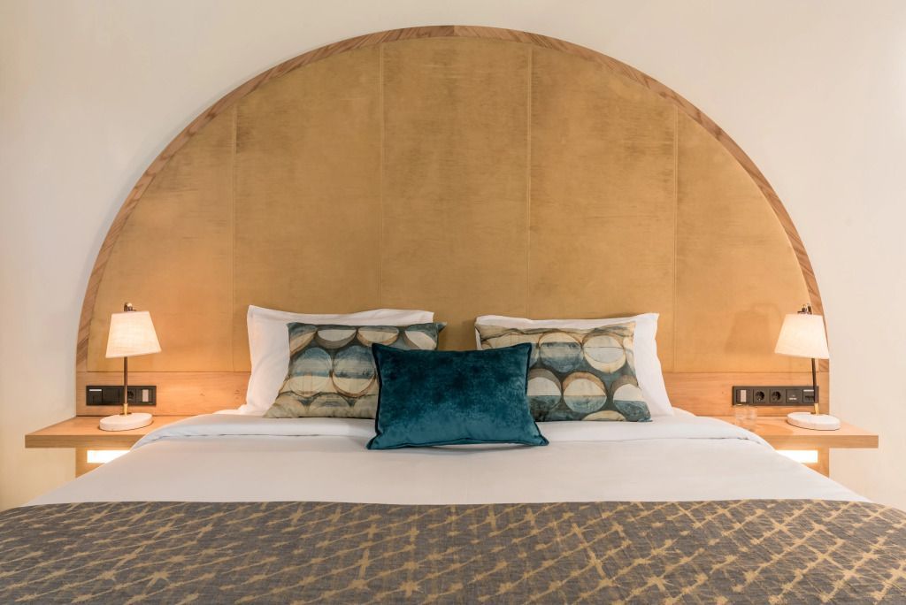 Luxuriöses Bett mit stilvollen Kissen und dekorativem Kopfteil