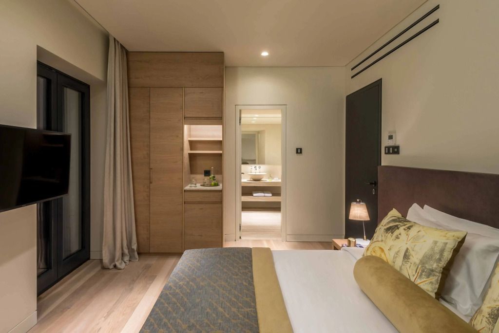 Geräumiges Doppelzimmer mit modernen Möbeln und Blick in das Badezimmer