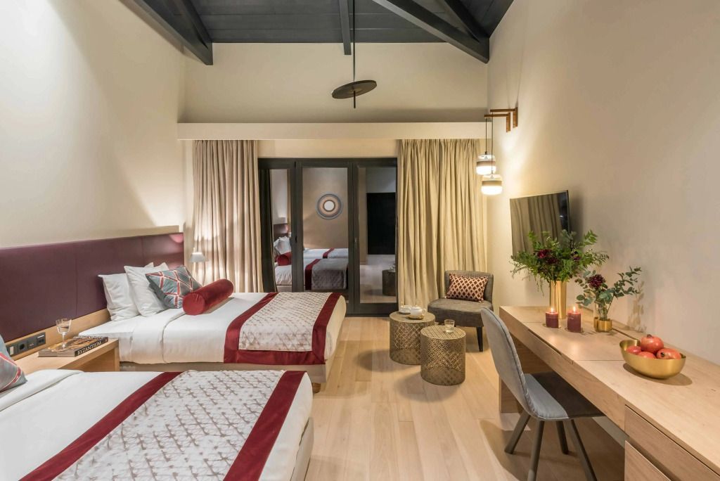 Großzügiges Schlafzimmer mit zwei Betten und Balkon im Euphoria Retreat