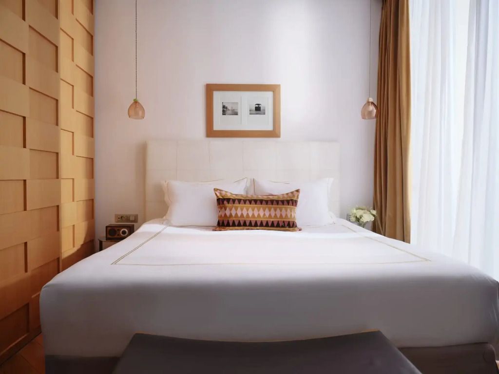 Komfortables Doppelbett mit eleganter Beleuchtung und Wandkunst