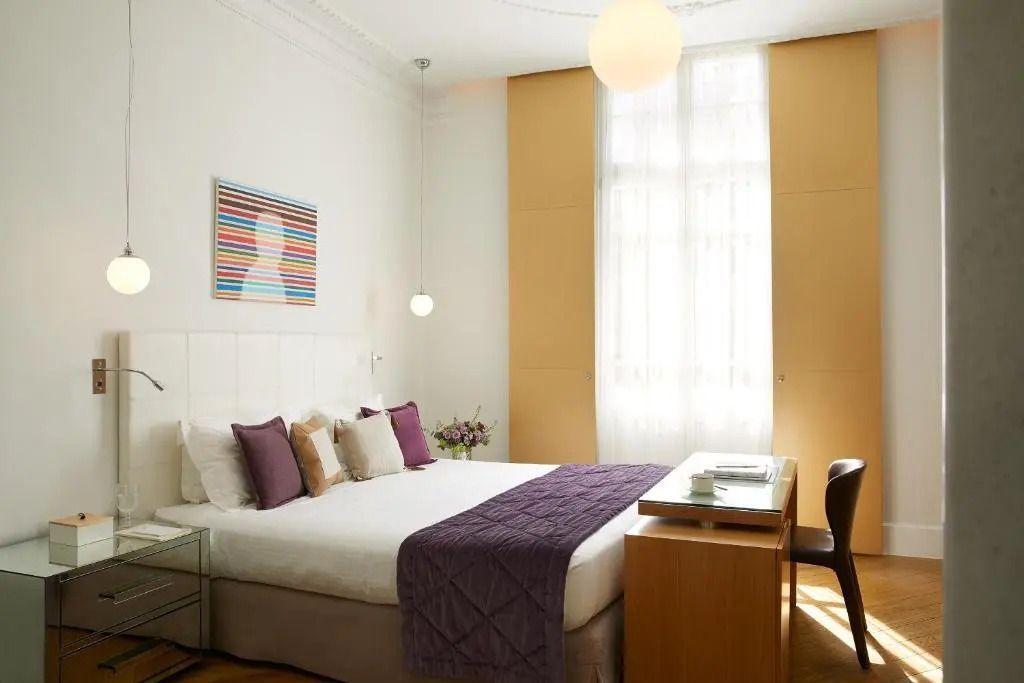 Luxuriöses Hotelzimmer mit violetten Akzenten und Kunst an den Wänden