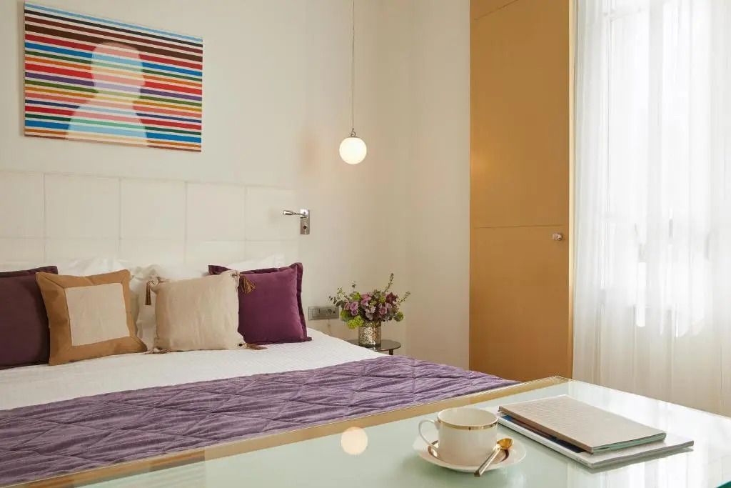 Luxuriöses Doppelbettzimmer mit stilvollen Kissen und Kunstwerk an der Wand