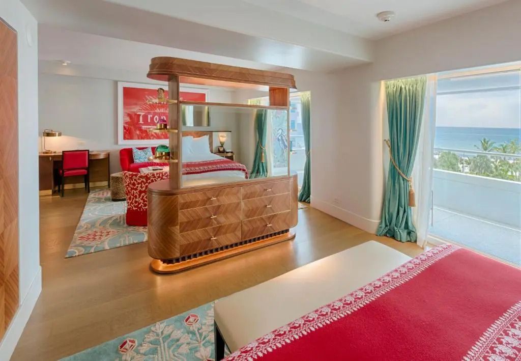 Weitläufige Suite mit kunstvoller Trennwand, großzügigem Bett und spektakulärem Meerblick.