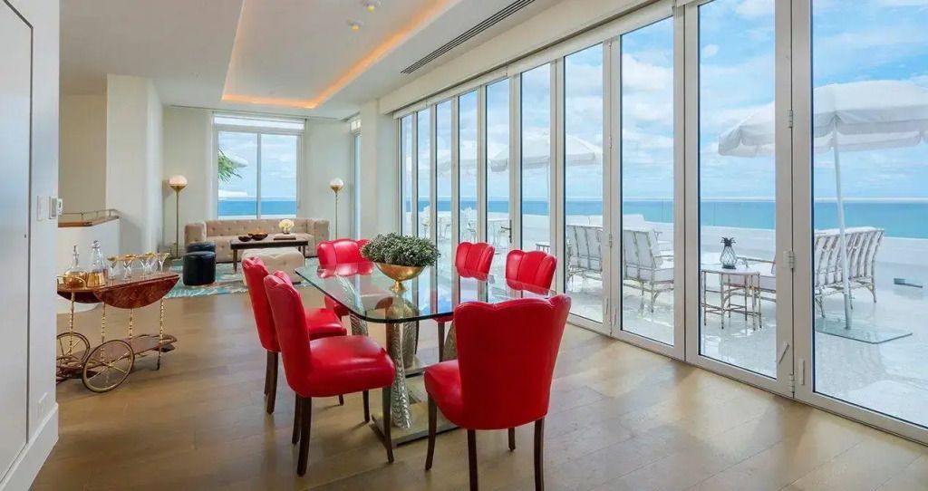 Essbereich mit roten Stühlen und Meerblick in der Penthouse Suite